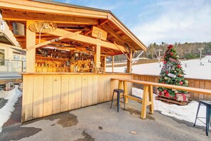 Ein hölzerner Barbereich im Freien mit Weihnachtsbaum und Schlitten.