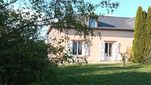 A house with a sloped roof, white shutters, and a well-maintained lawn. - LE P'TIT LOGEMENT DE LOR'PHEE (CHANTEPIE)