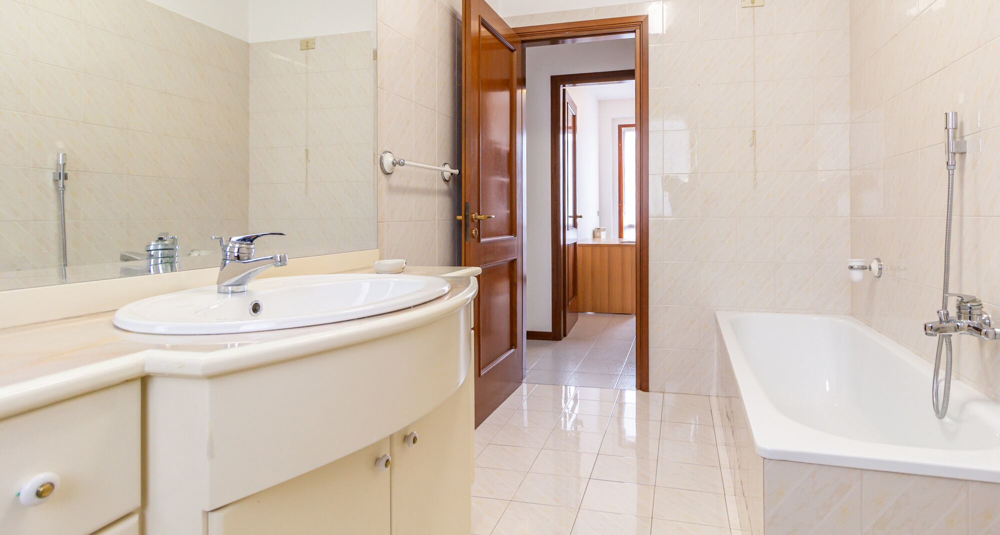 Een moderne badkamer met een wastafel, spiegel en bad.