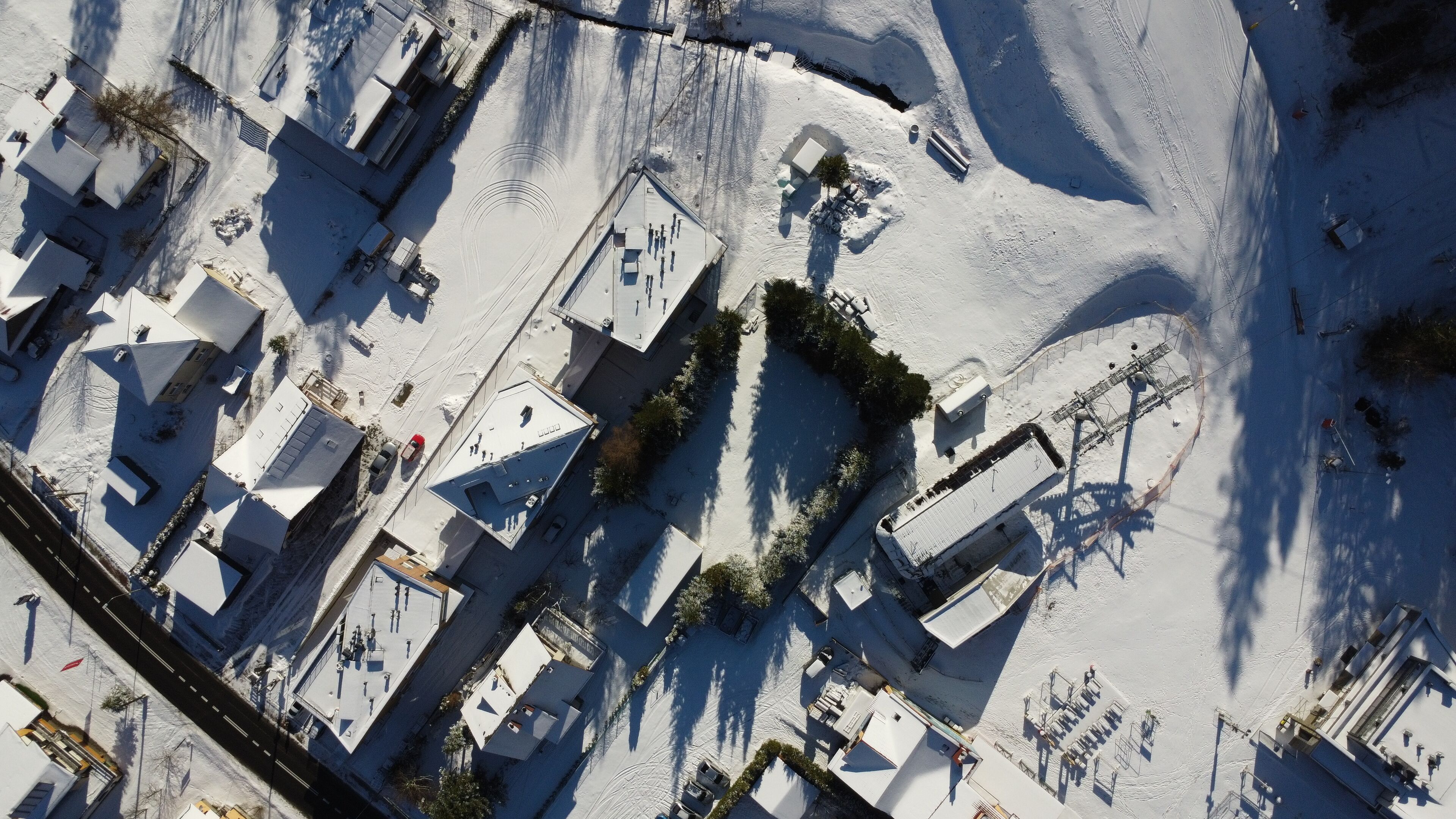 An aerial view of a residential area with multiple buildings, including houses and a large commercial building with a flat roof.