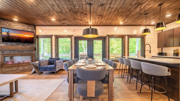 A modern kitchen with a central island, wooden ceiling, and large windows. - *Stunning 4BD Lodge w/ POOL + Hot Tub + Near TOWN* (Pigeon Forge)