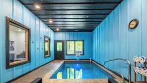 A pool area with a blue wall, a clock, and a towel rack. - *Stunning 4BD Lodge w/ POOL + Hot Tub + Near TOWN* (Pigeon Forge)
