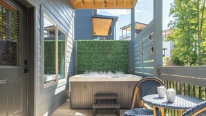 A wooden deck with a hot tub, a bench, and wicker chairs. - *Stunning 4BD Lodge w/ POOL + Hot Tub + Near TOWN* (Pigeon Forge)