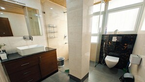 Et moderne badeværelse med en stor vask, et mørkt træskab og et toilet.