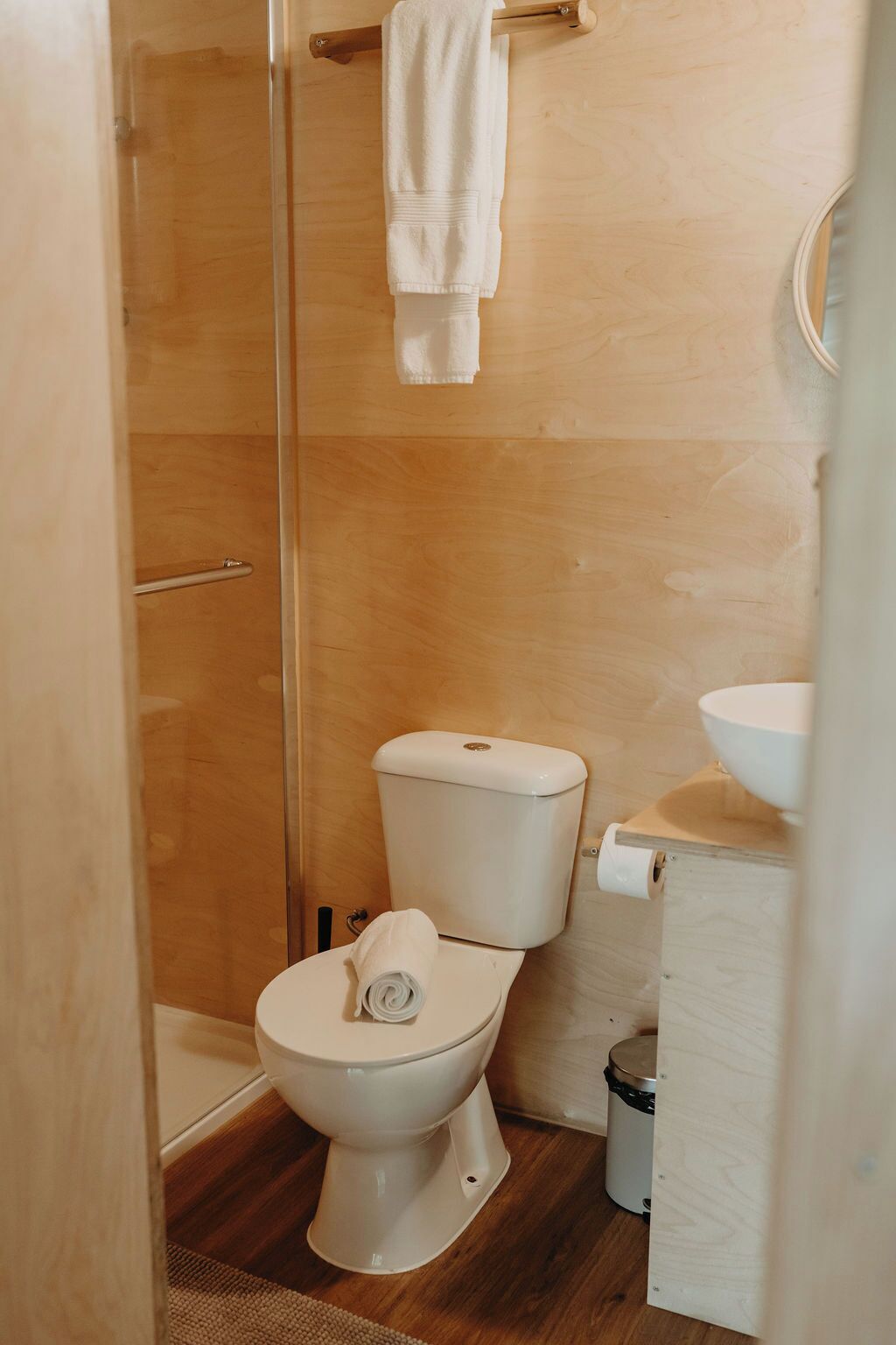 A small, modern bathroom with a toilet, a sink, and a shower area.