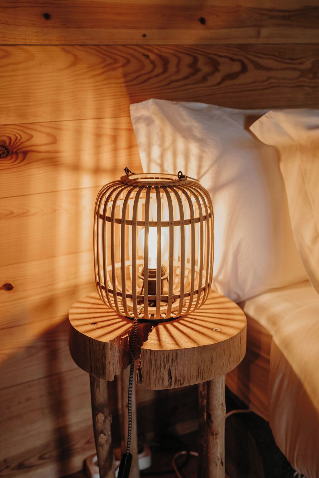 A wooden bed with a hanging light fixture.