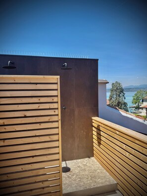 A wooden door leading to a covered outdoor area with a view of a body of water and distant mountains. - Sunset Sirmione Lake View (Sirmione)