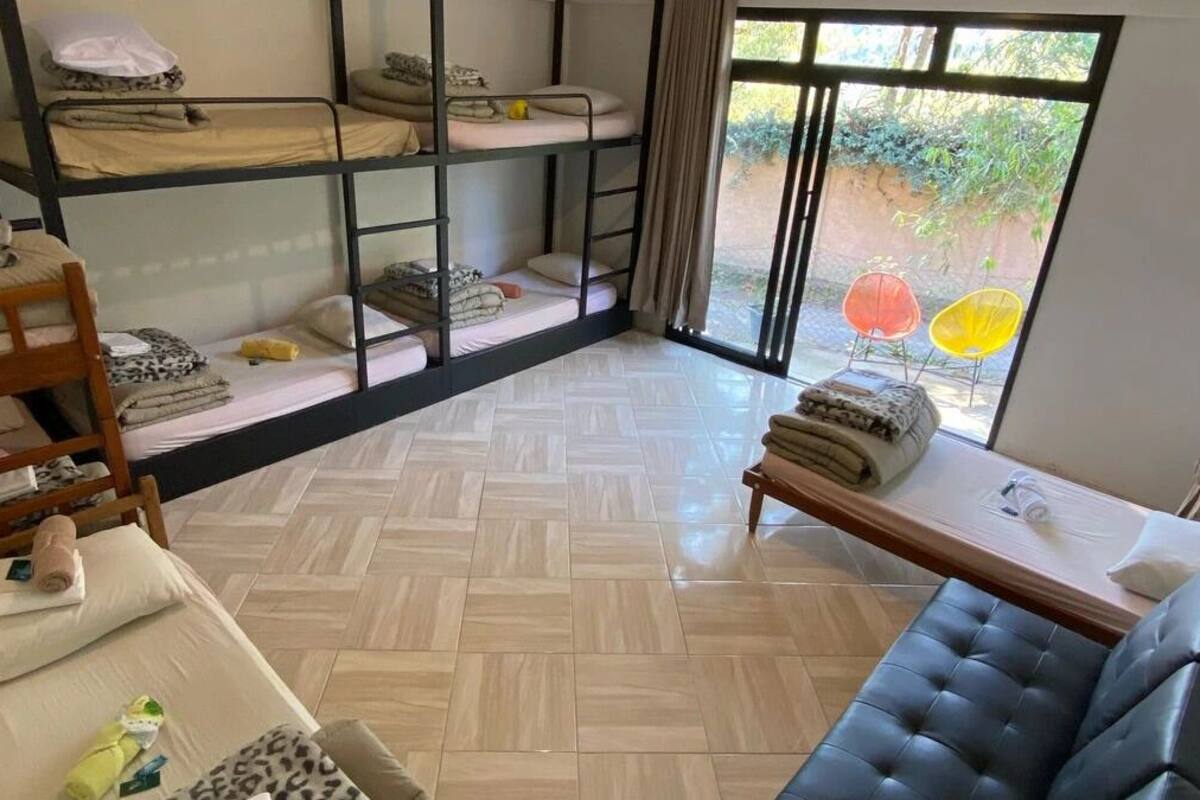 Una habitación con literas, un sofá, una mesa y vistas al exterior.