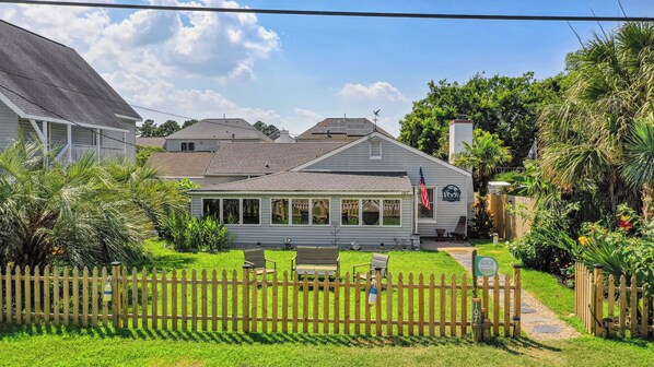 A house with a fenced backyard, a flag, and a sign reading "Beach House." - Charming 3-bedroom house with AC, WiFi in fantastic Hampton (Hampton)