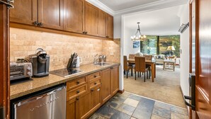 Eine Küche mit Holzausstattung, einem Edelstahlkühlschrank, einer Kaffeemaschine und einem Toaster.