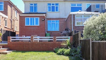 A residential area with houses, a wooden fence, and a grassy yard.