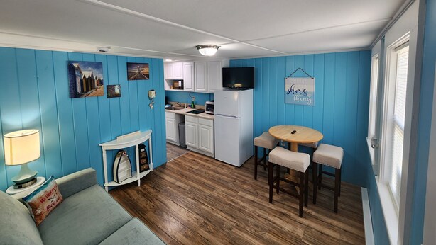 A compact living space with a kitchenette, a dining area, and a sofa.
