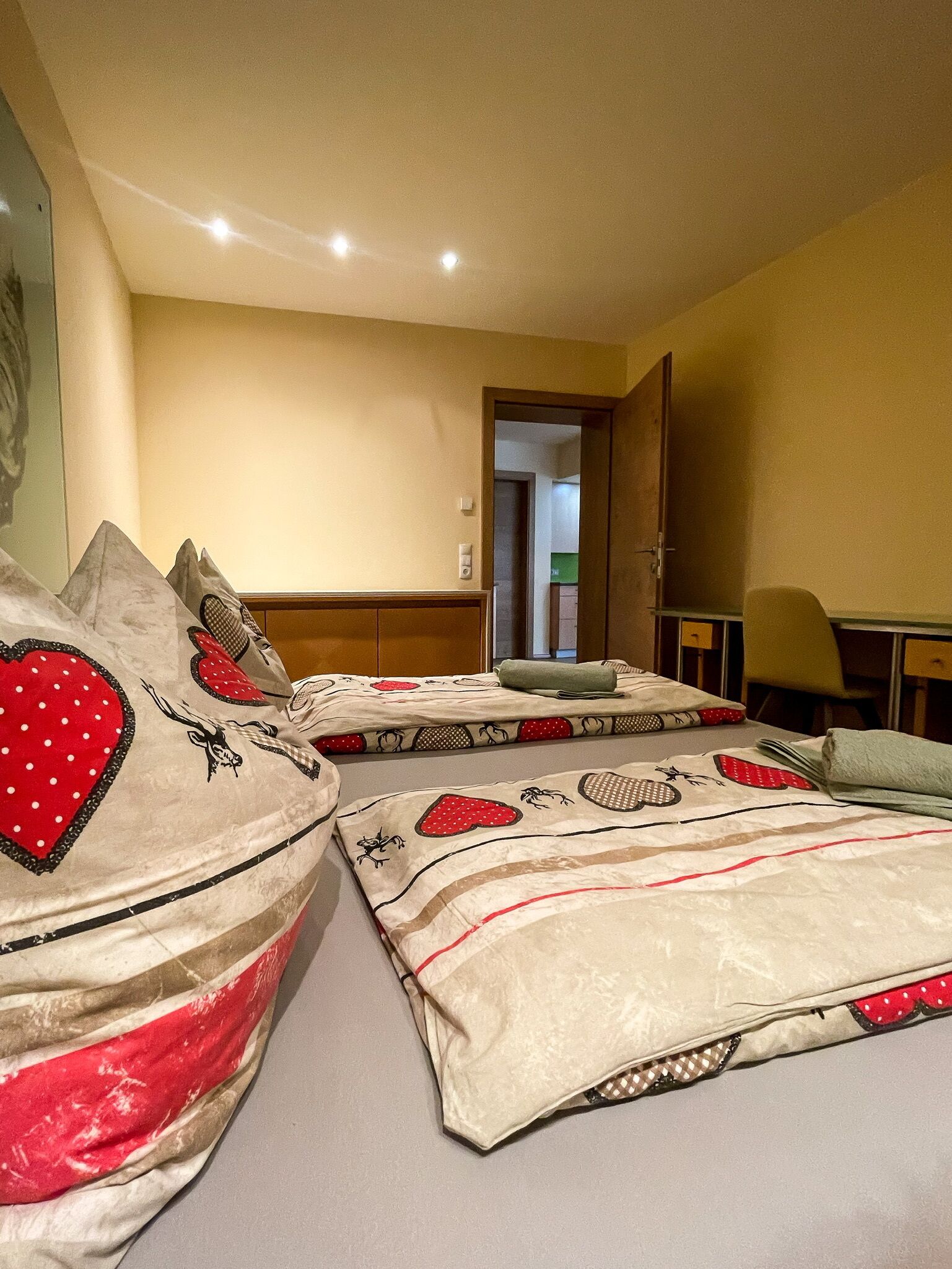 Habitación de hotel con dos camas, un escritorio y una silla.