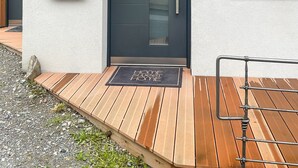 A modern house with a dark grey door, a metal coat rack, and a small mailbox. - Apartment Waldnah (Fließ)