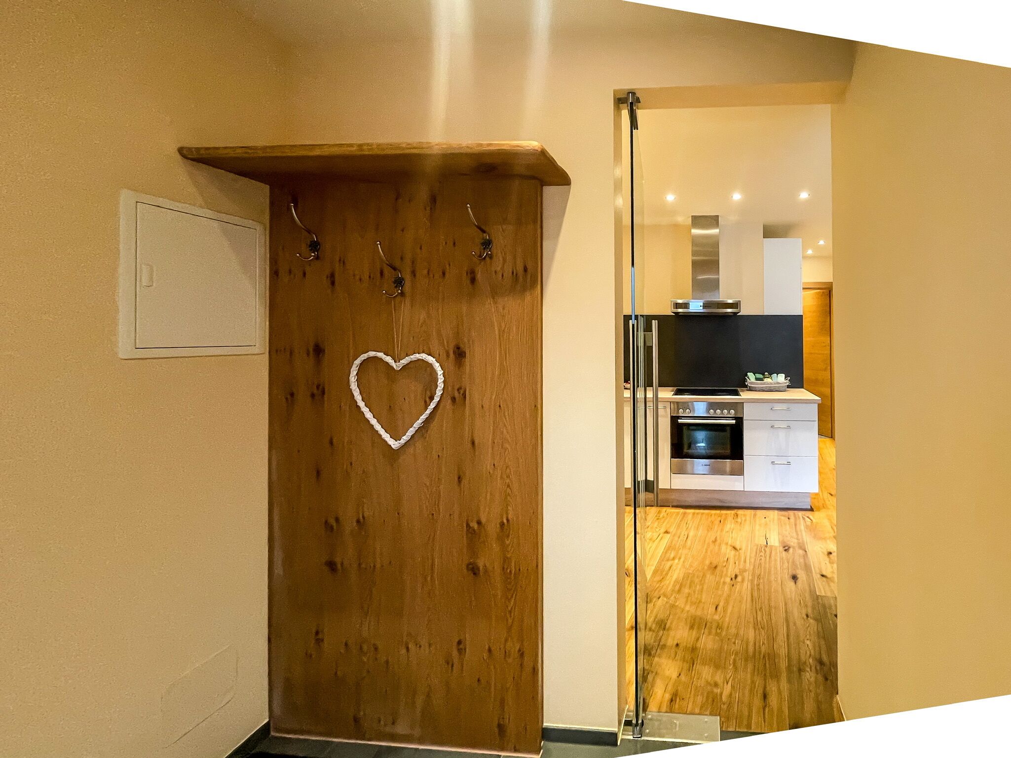 Una puerta de madera con un adorno con forma de corazón y un ventanal pequeño.