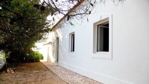 A white building with two windows and a gravel pathway leading to the entrance. - Beautiful property in southern Portugal (Algarve) near Estômbar golf course (Unknown)