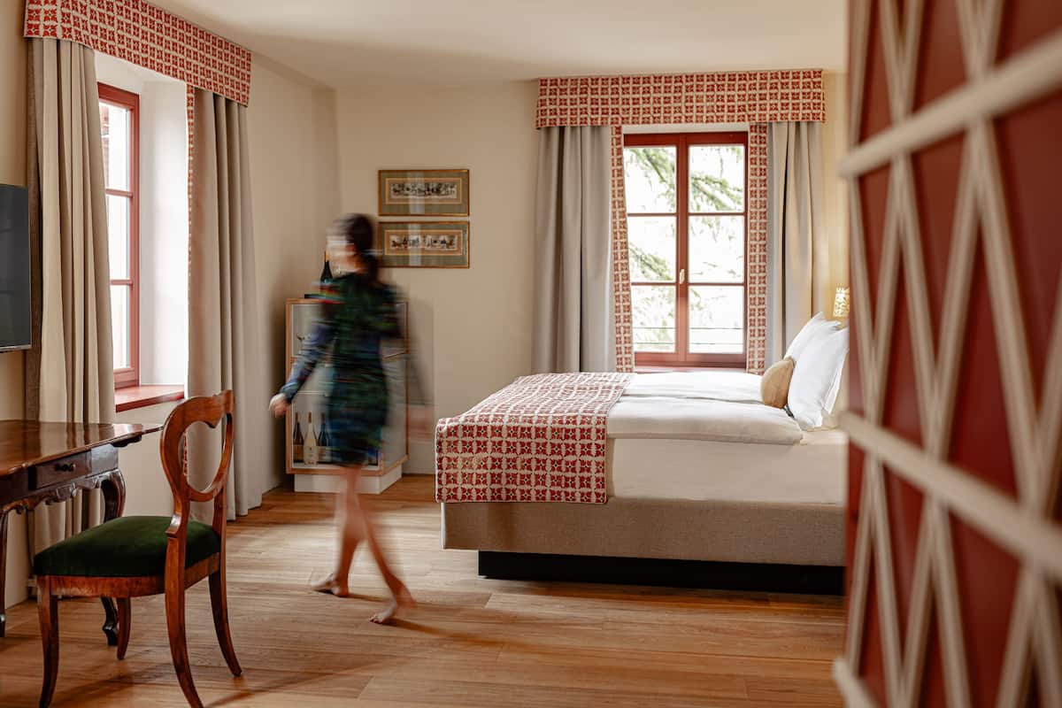 A bedroom with a bed, a desk, and a chair.