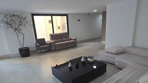 Un salon moderne avec un canapé, une table basse et une plante en pot.