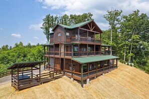 A two-story log cabin with a balcony and a covered porch. - Brand New Luxury Mountain Scape Swimming Pool Air Hockey Pool Table 3 Fire Place (Gatlinburg)