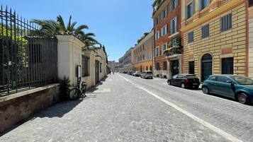 Eine Kopfsteinpflasterstraße gesäumt von historischen Gebäuden, mit abgestellten Fahrrädern am Bürgersteig und parkenden Autos am Straßenrand.