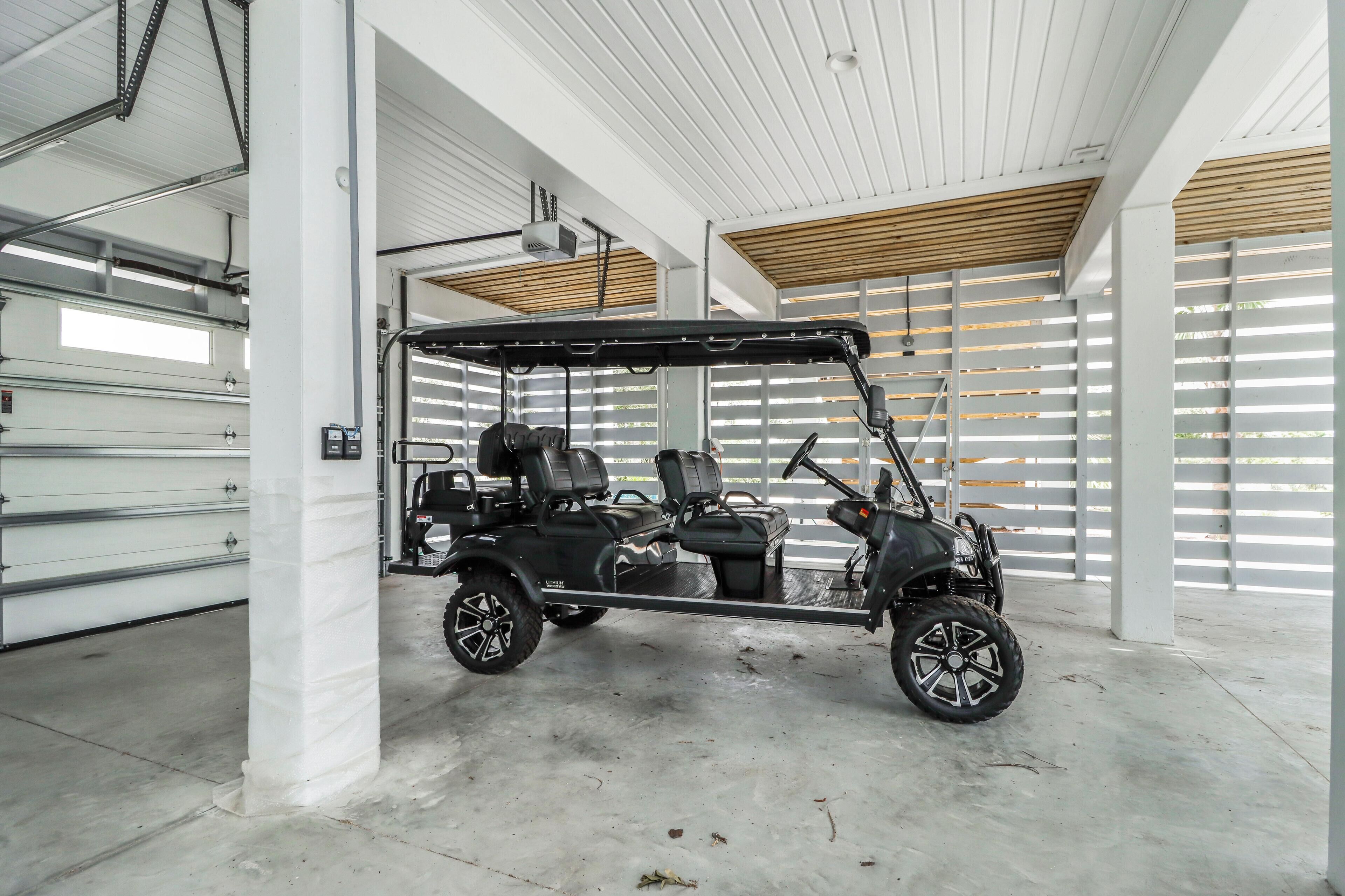 A modern garage with a black golf cart parked inside.