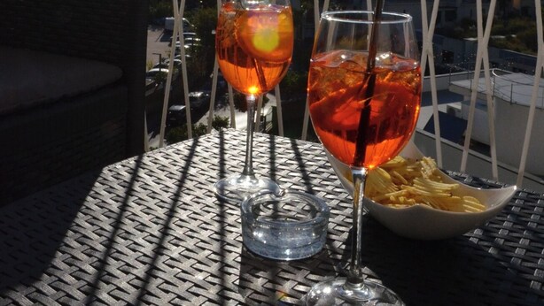 A balcony with two glasses of drink and a bowl of fries, overlooking a cityscape. - Sweet Emily, Panoramic comfort just a stone's throw from Sorrento! (Sant'Agnello)
