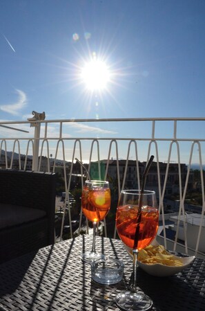 A balcony with two glasses of drink and a bowl of fries, overlooking a cityscape. - Sweet Emily, Panoramic comfort just a stone's throw from Sorrento! (Sant'Agnello)