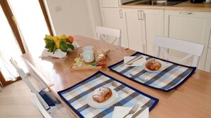 A dining table with two placemats, a croissant, a plate, a napkin, and cutlery. - Sweet Emily, Panoramic comfort just a stone's throw from Sorrento! (Sant'Agnello)