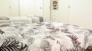 Un dormitorio con cama, armario y estante con un objeto decorativo.