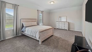 A bedroom with a bed, dresser, and a mirror.