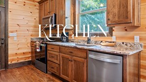 A kitchen with wooden cabinets, granite countertops, a built-in microwave, and a dishwasher. - Standing Bear | Romantic Forest Escape for Couples (Broken Bow)