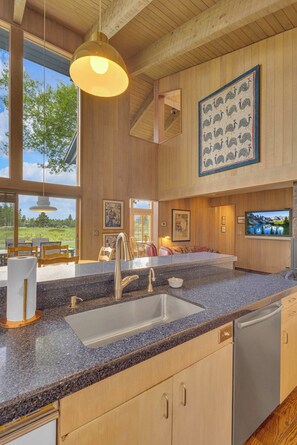 A modern kitchen with granite countertops, stainless steel appliances, and wooden cabinetry.