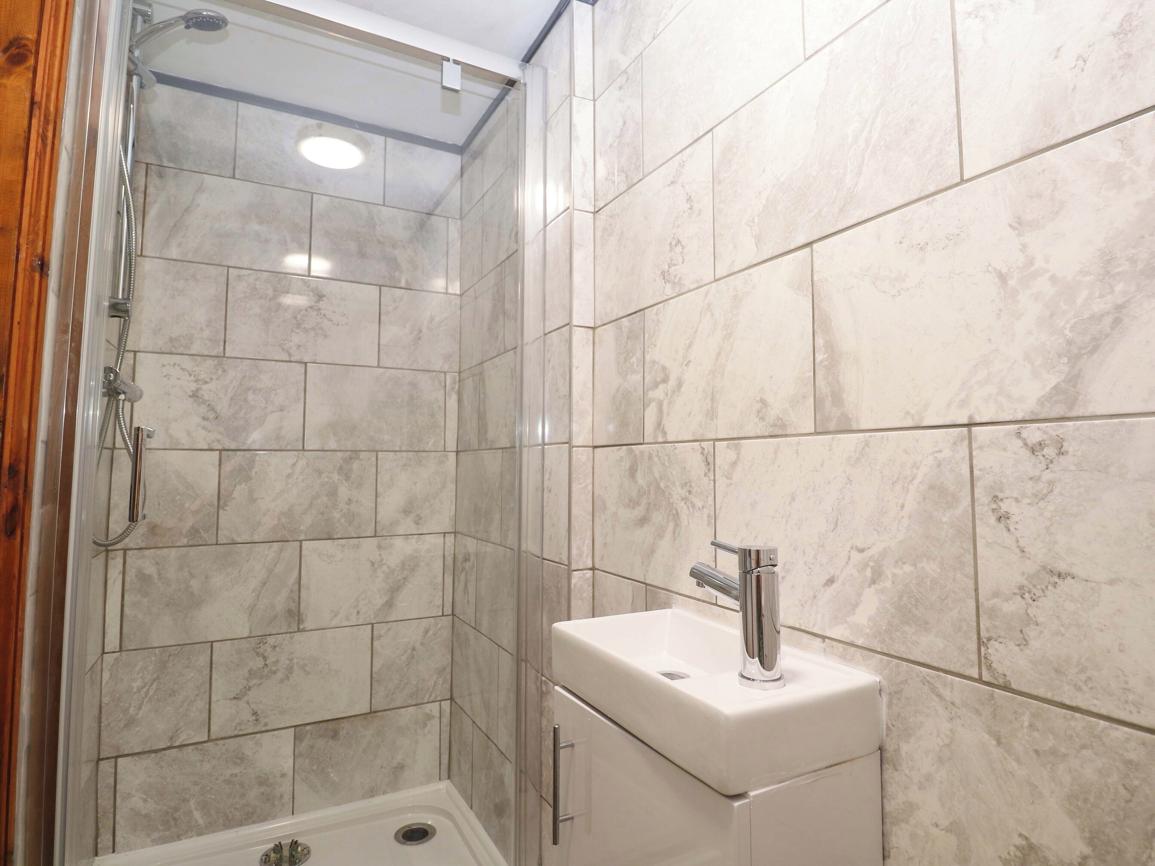 Un baño con ducha, lavamanos e inodoro.
