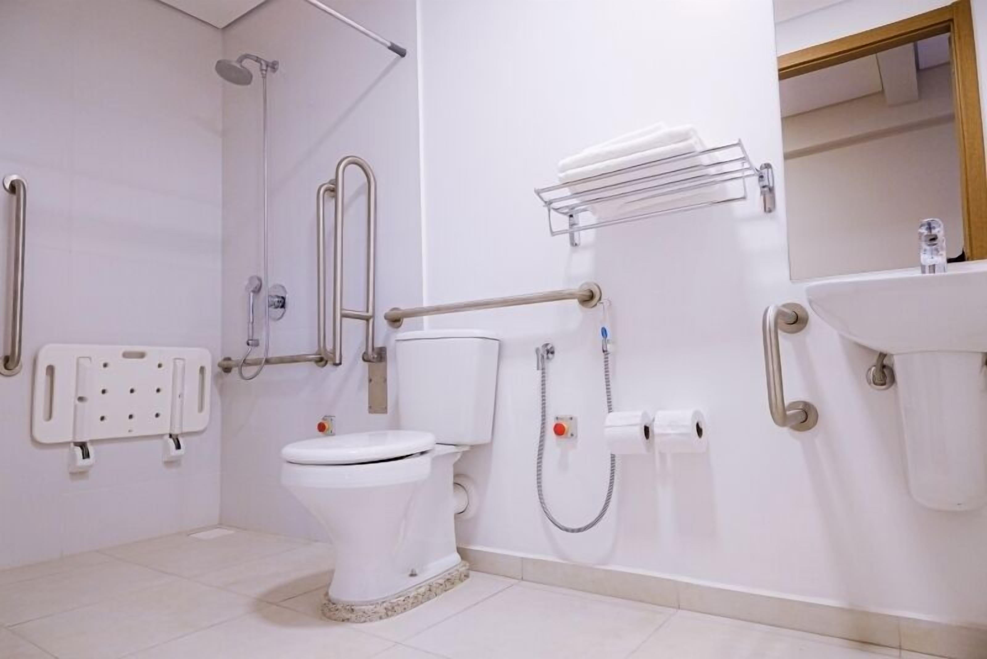 A modern bathroom with a toilet, shower, and sink.