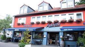 A red and blue building with a sign for 'Bäckerei' and 'Adolph's' on the facade. - Adolph*s.hotel (Cologne)