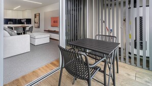 A modern interior with a dining area, a sofa, and a kitchen in the background. - GuestReady - Beach and Pool Escape in Gaia (Vila Nova de Gaia)