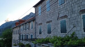 A stone building with multiple windows and a cobblestone street. - Old bakery house (Risan)
