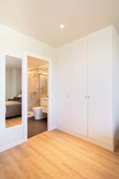 Une chambre dotée d’une grande armoire, d’un lit et d’une salle de bain avec douche et toilettes.
