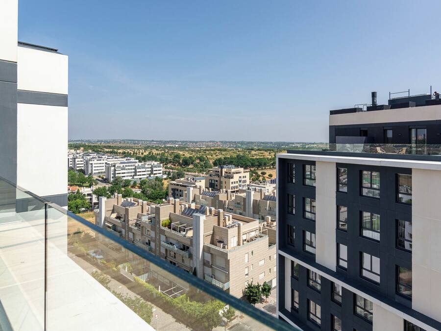 A modern building with a glass balcony overlooking a cityscape.