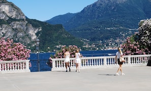 A promenade with a view of a mountainous landscape and a body of water.