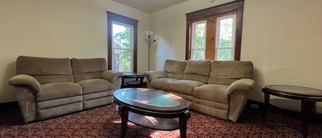 A living room with two sofas, a coffee table, and a lamp.