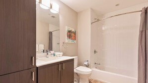 A modern bathroom with a shower, toilet, and vanity.