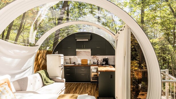 A cozy, circular tent-style accommodation with a kitchenette, a sofa, and a dining area, surrounded by a forest. - Sunken Escapes #3 Kit's Retreat (Kings County)