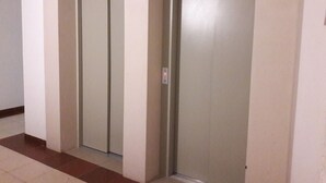 A hallway with two closed elevator doors and a tiled floor. - Clube Praia da Rocha 3 Great Flat 532 (Portimão)