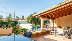 Une terrasse extérieure avec une table, des chaises et une voiture garée à proximité.