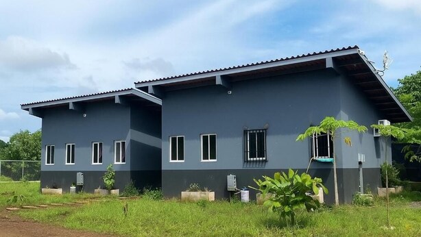 A two-story building with a flat roof and a dark exterior.