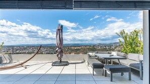A rooftop terrace with a view of a cityscape, a hammock, and outdoor furniture. - House 5p with garden in the heart of Saint-Raphaël (Saint-Raphaël)