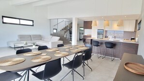 A modern living space with a dining area, kitchen, and staircase. - House 5p with garden in the heart of Saint-Raphaël (Saint-Raphaël)