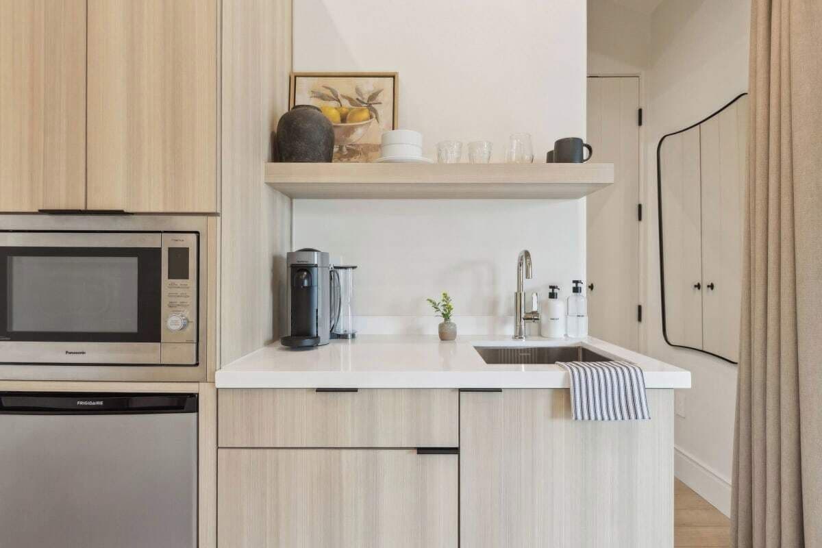 A modern kitchen with a microwave, coffee maker, and sink.