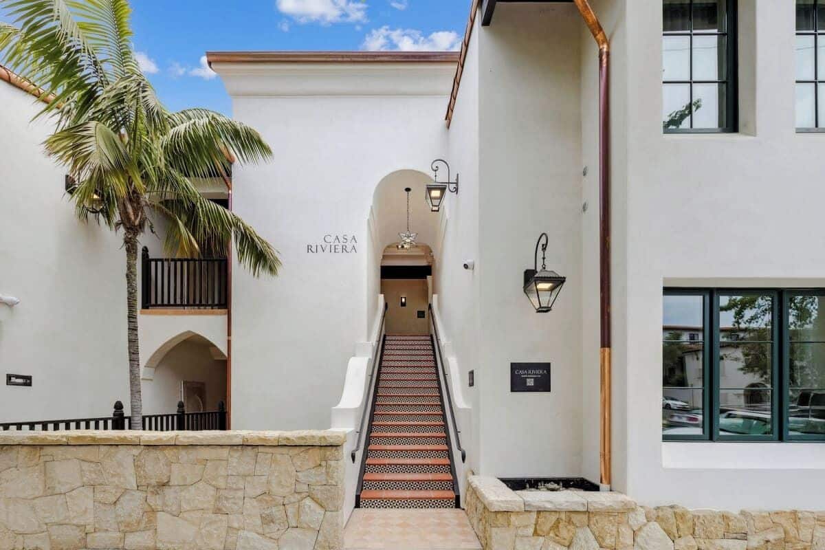A staircase leading to a building labeled 'CASA RIVIERA' with stone walls and a palm tree.